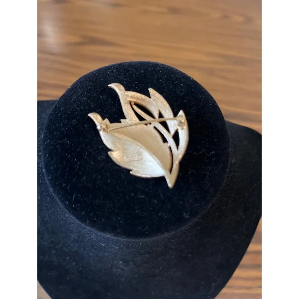 Crown Trifari gold tone and white enamel leaf design brooch